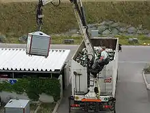 Vehículo vaciando un contenedor de vidrio.