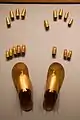 Cubrededos para los dedos de manos y pies de pan de oro, y sandalias de oro, en exhibición en el Museo Metropolitano de Arte.