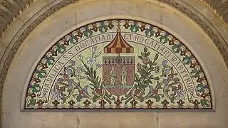 Tímpano del portal: mosaico armoriée con Donatio y su lys, Rogatio y su rosa