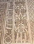 Motivos arabescos y piñas junto con inscripciones caligráficas alrededor del mihrab de la Madrasa de Ben Youssef, en Marrakech (siglo&nbsp;XVI)