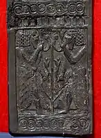 Panel de marfil tallado que muestra a jóvenes egipcios barbudos flanqueando el tallo y las flores de loto. De Nimrud, Irak. Museo de Irak.