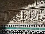 Inscripción con caligrafía arábica en letra cursiva, tallada en estuco en la Madrasa de al-Attarine en Fez (principios del siglo&nbsp;XIV)