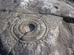 Marcas de cazoleta y anillos grabados en la roca en Laxe das Rodas, Galicia.