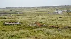 Otros restos del transmisor con edificaciones rurales de fondo.