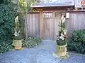 Dos kadomatsu colocados frente a la puerta de una casa tradicional japonesa