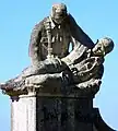 Soldado sujetando a un compañero caído, a la izquierda del monumento