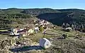Vista general del caserío de Sesga (Ademuz), desde la era del cementerio, con detalle de un rulo de piedra.