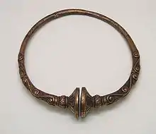 Torques celta tipo buffer del siglo IV a. C., realizada en bronce, procedente de Francia