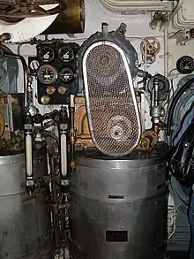 The vapour-compression distiller installed in the submarine's engine room. A cylindrical drum water vessel carries the compressor and its electric motor with belt drive above it.