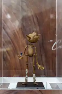 Fotografía de una escultura de Pinocho hecha con resina y plastilina epóxica usada en el filme de Guillermo del Toro de 2022. Se encuentra dentro de un capelo de acrílico.